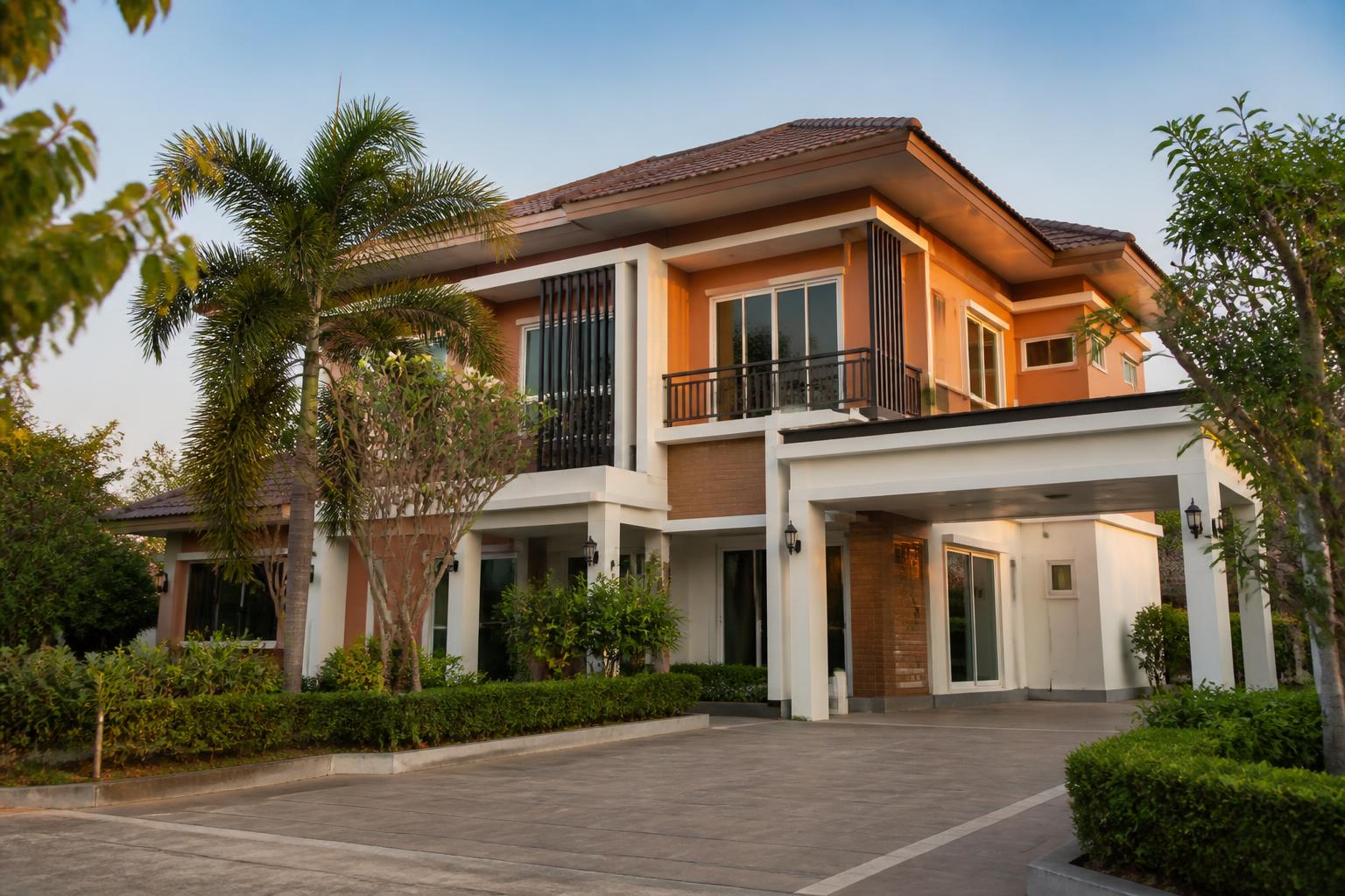 Two-storey detached house with carport in a Khon Kaen housing estate at golden hour